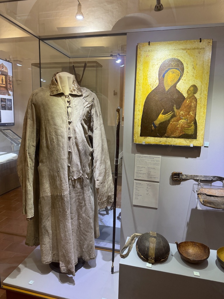 Kirillo-Belozersky Tarih ve Mimarlık Müzesi - Solda manastırın kurucusu Aziz Kirill Belozersky'ye ait olan, 14.-15. yüzyıldan kalma kaba kumaştan yapılmış orijinal keişlik/inziva cübbesi (svita), ortada Aziz Kirill'ın kullandığı ahşap yürüyüş bastonu, sağdaki ikona Aziz Kirill'ın yanından ayırmadığı söylenen Meryem Ana ve Çocuk İsa ikona tasviri, ön planda Aziz Kirill'a ait ahşap su kabı, çanak ve kişisel deri kemer eşyaları görülüyor
